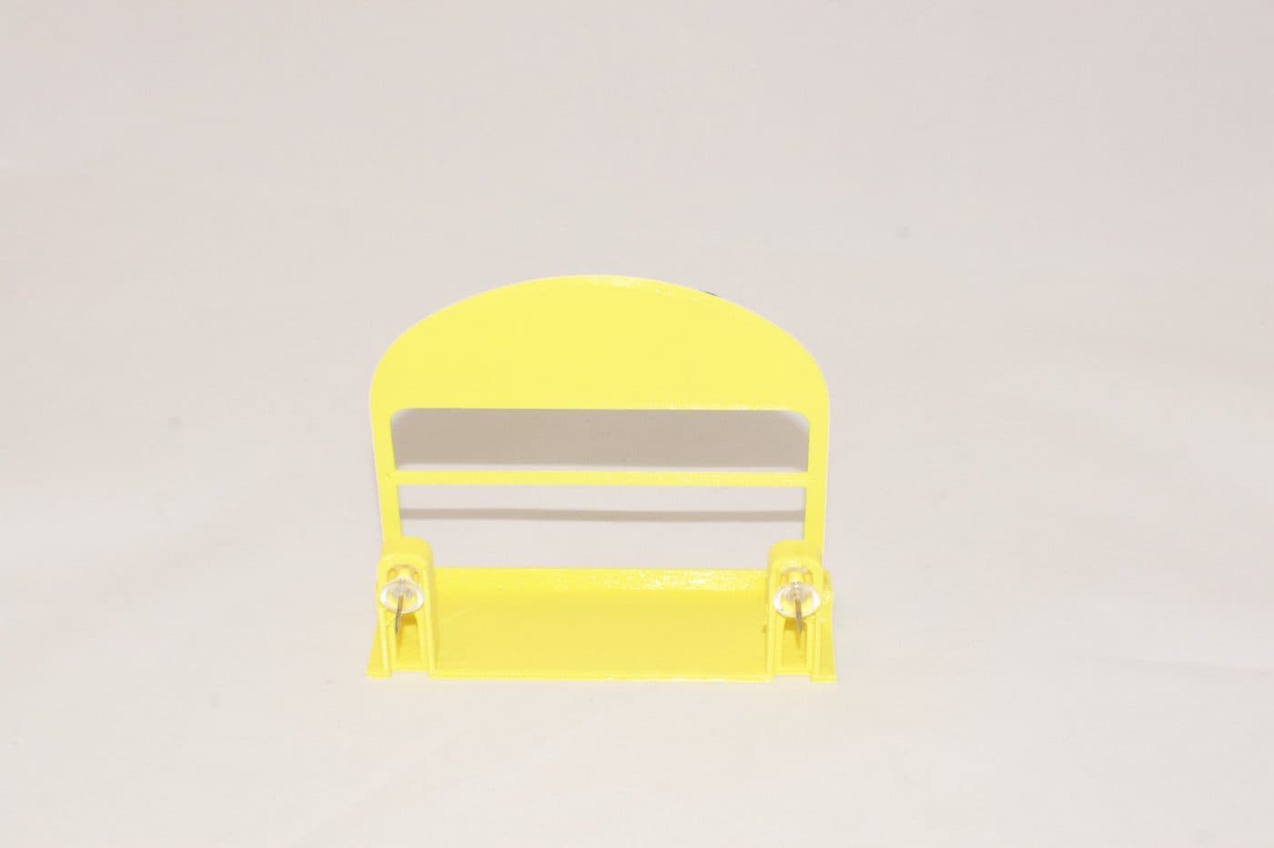 The Solar Strive card stand from the front: a safety-yellow moulded holder with a slot for cards, empty, on a white surface.